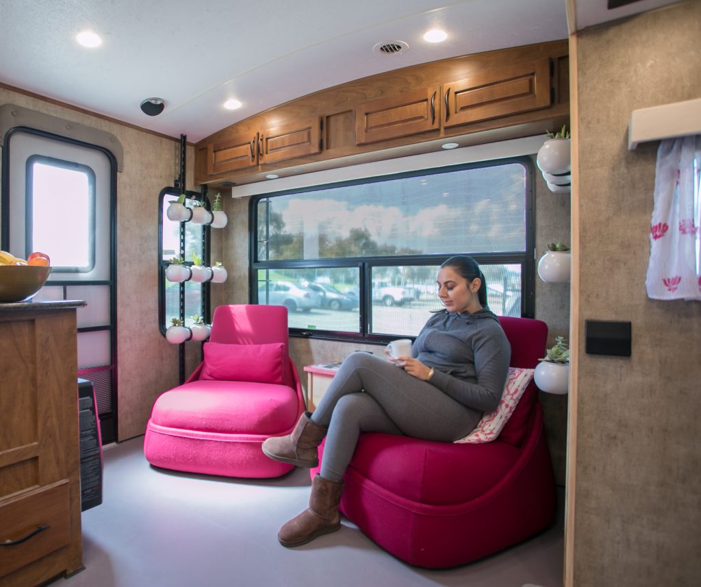 Woman sitting on pink chair in trailer